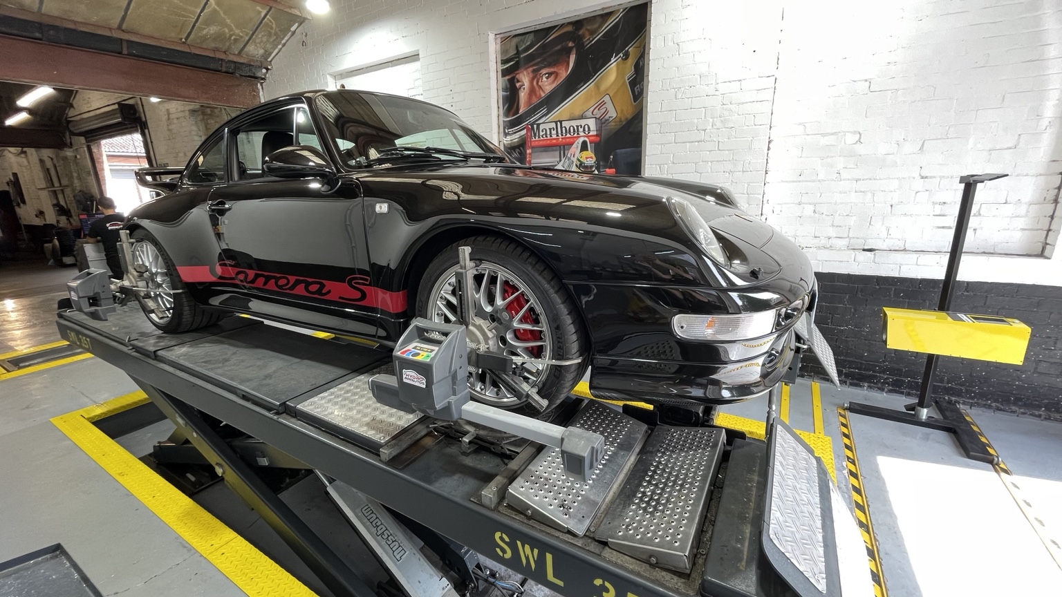 Porsche 911 Carrera S receiving four-wheel alignment